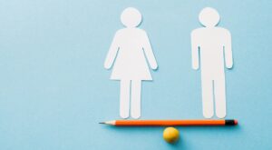 Equilíbrio entre casal representado por figuras de papel, simbolizando diálogo e mediação no divórcio.